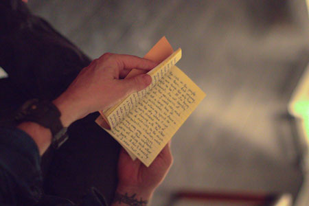 An audience member holds open Jason Stoneking's Bespoke Book at the Lit Lounge in Skibbereen